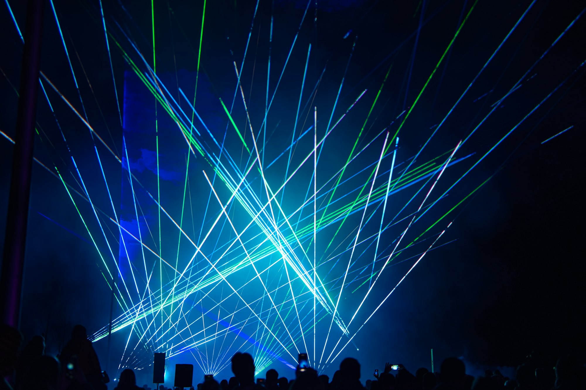 Blue green lasers cutting through darkness